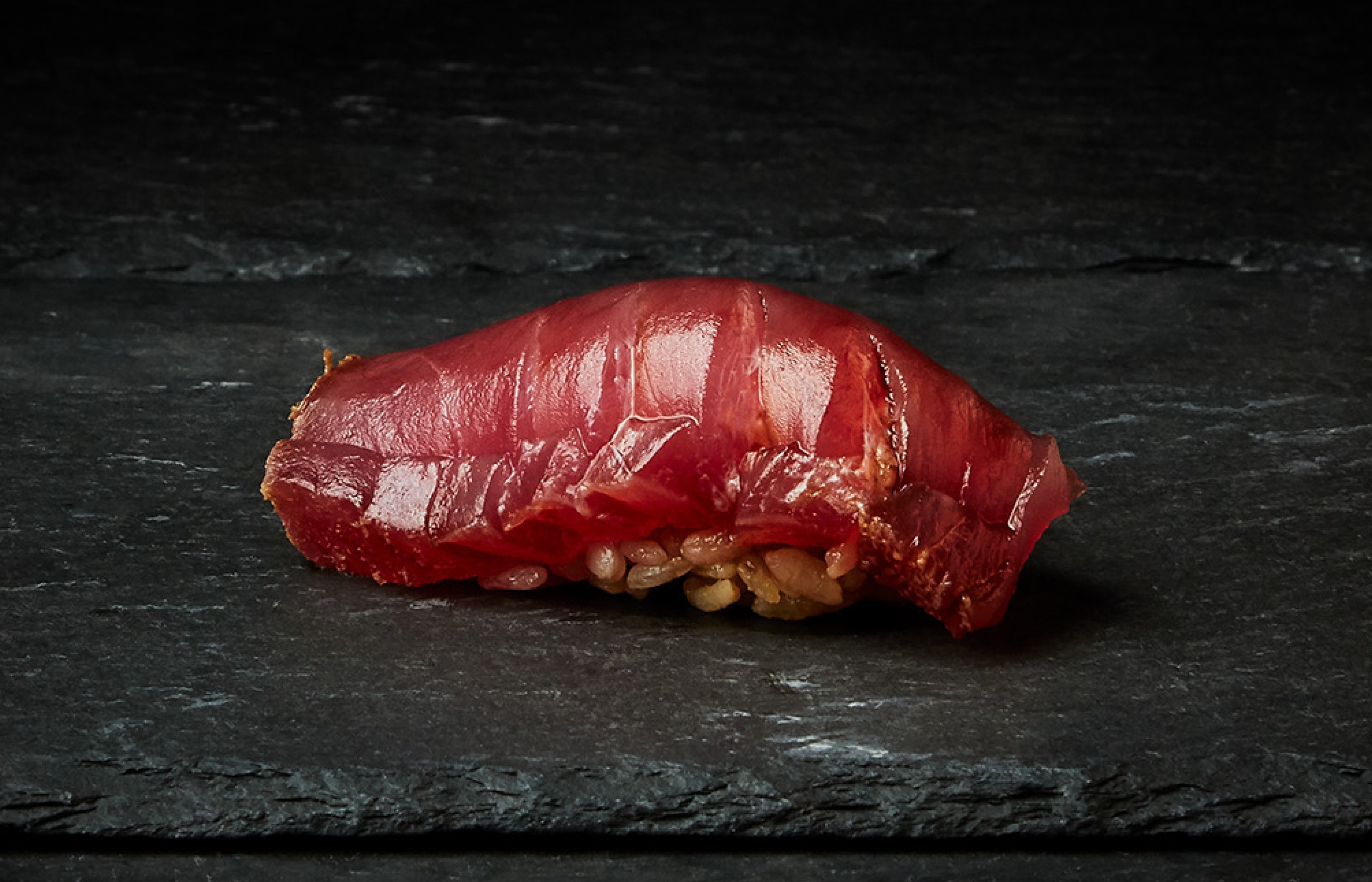 Sojagravad tonfisk Akami tsuke. Görs med röd risvinäger i risblandningen – en gammal risvinägerstil som användes i originalversionen av edomae sushi. Den görs på det överblivna riset från mäsken vid saketillverkning som sedan oxiderar, vilket leder till den röda färgen. Detta ger en lite mer rustik smak.